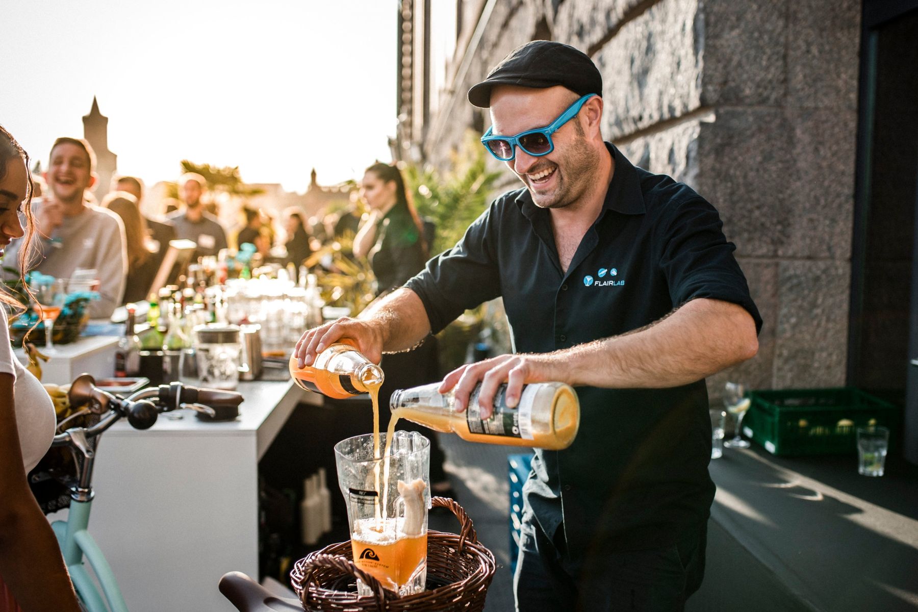 Bartender mixing drinks on the Spree terrace, with guests in the background