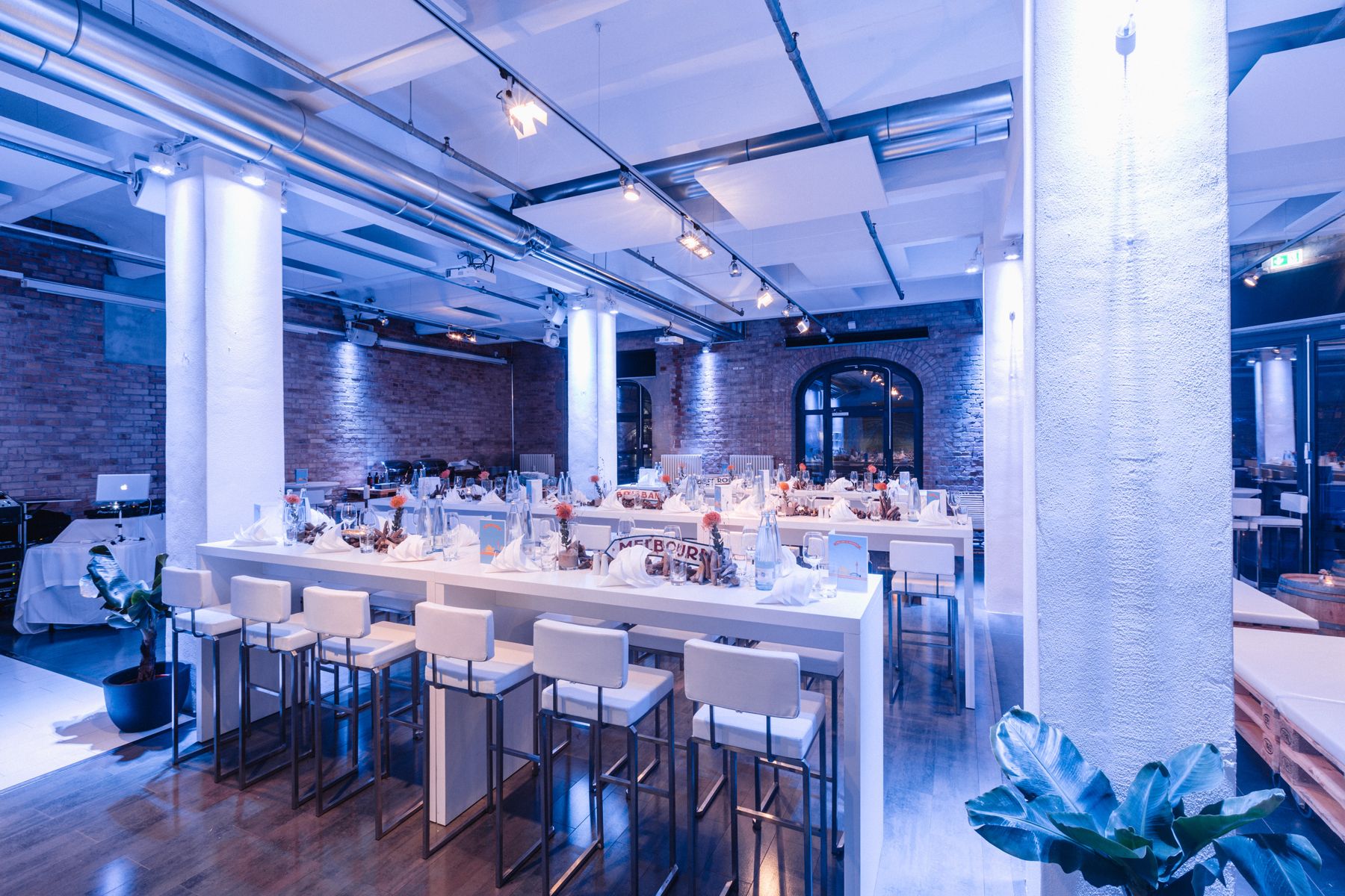 Event hall with blue lighting and laid tables
