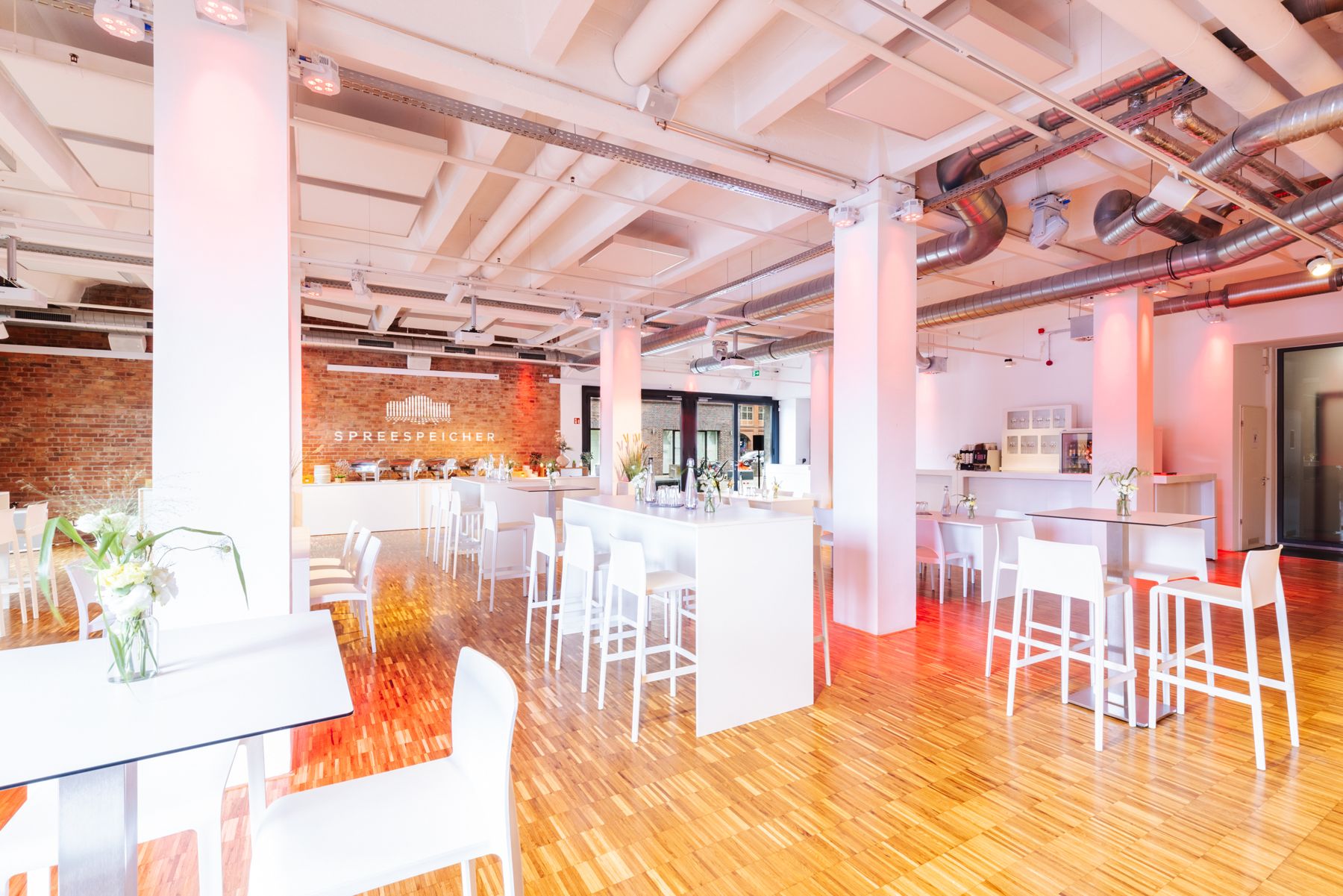 Empty event hall with white columns and red lighting