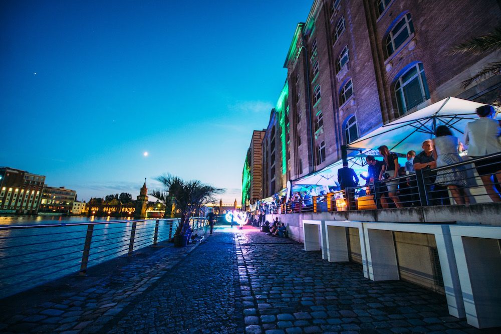 Illuminated Spree terrace and warehouse building in the evening
